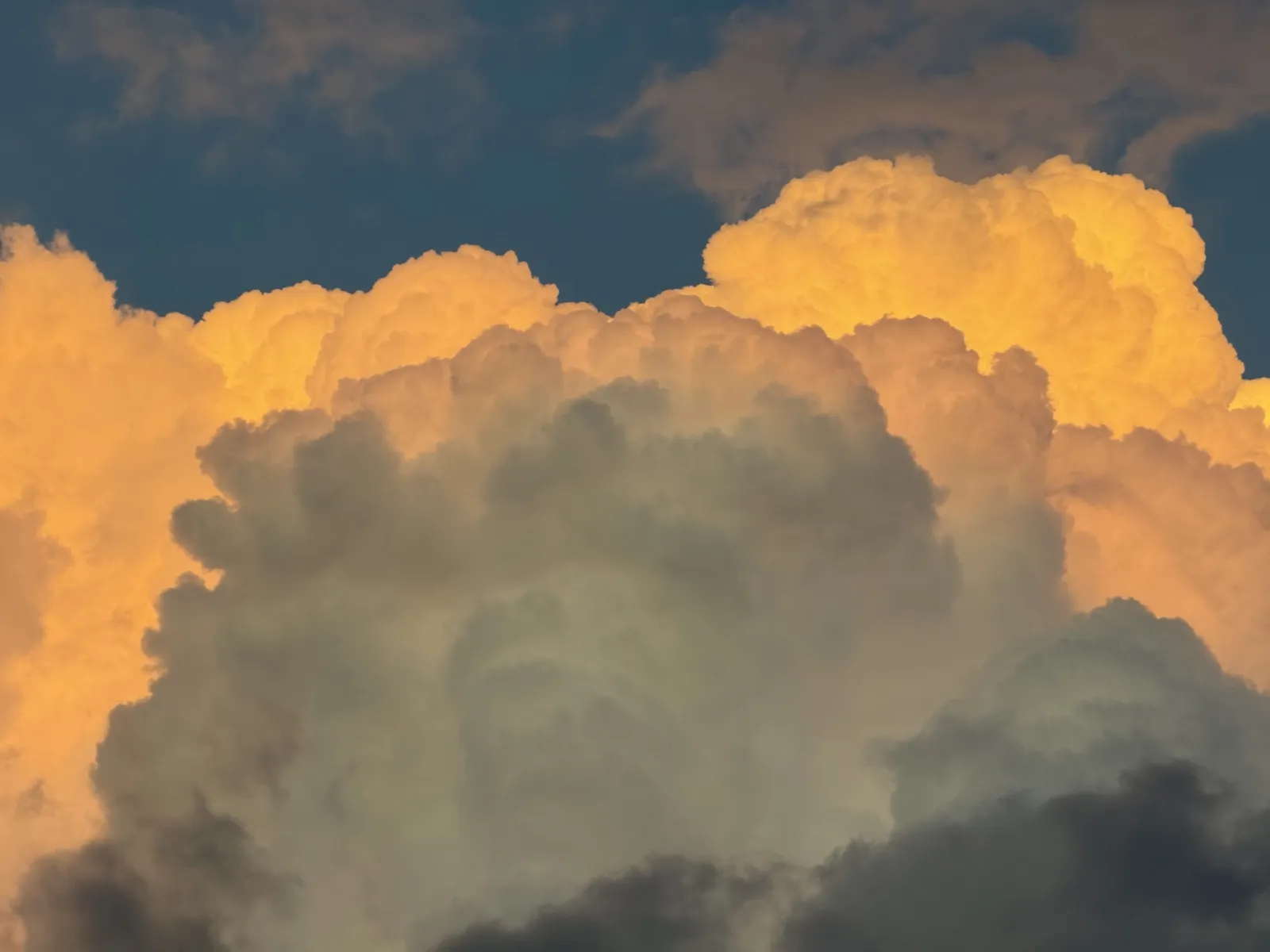 Golden sunset clouds against deep blue sky